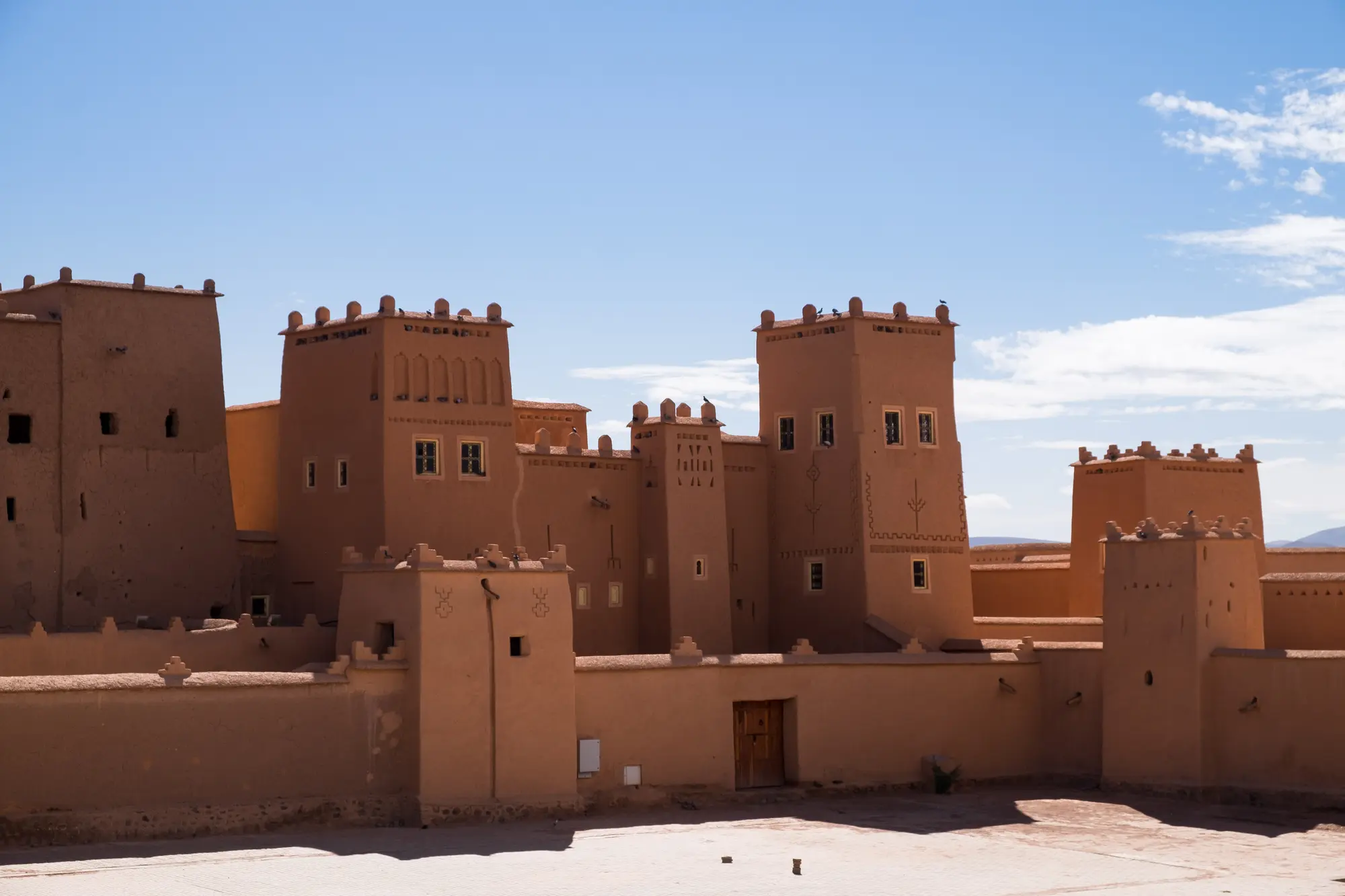 The Taourirt Kasbah's red earthen towers against a clear sky in Ouarzazate, Morocco
