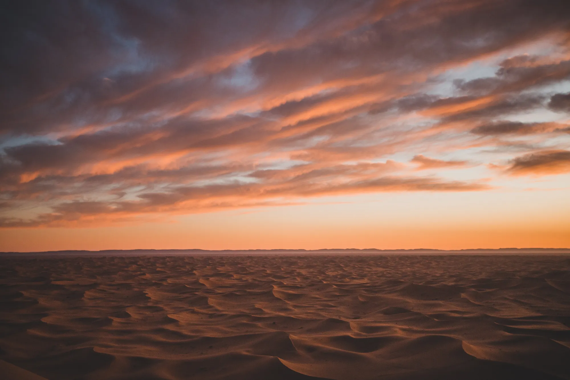 Sunset over the rolling dunes of the Sahara desert near Mhamid, Morocco